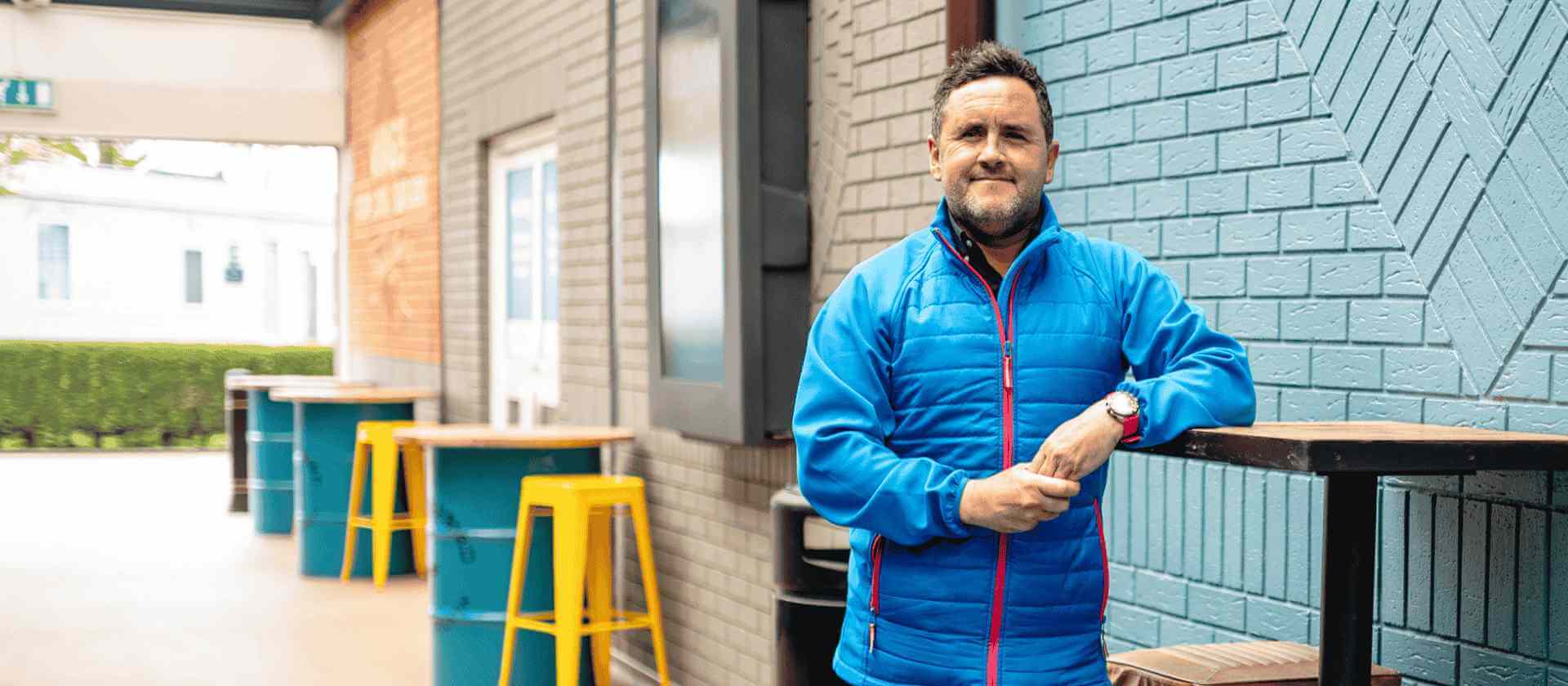 Image of manager smiling stood in front of tables