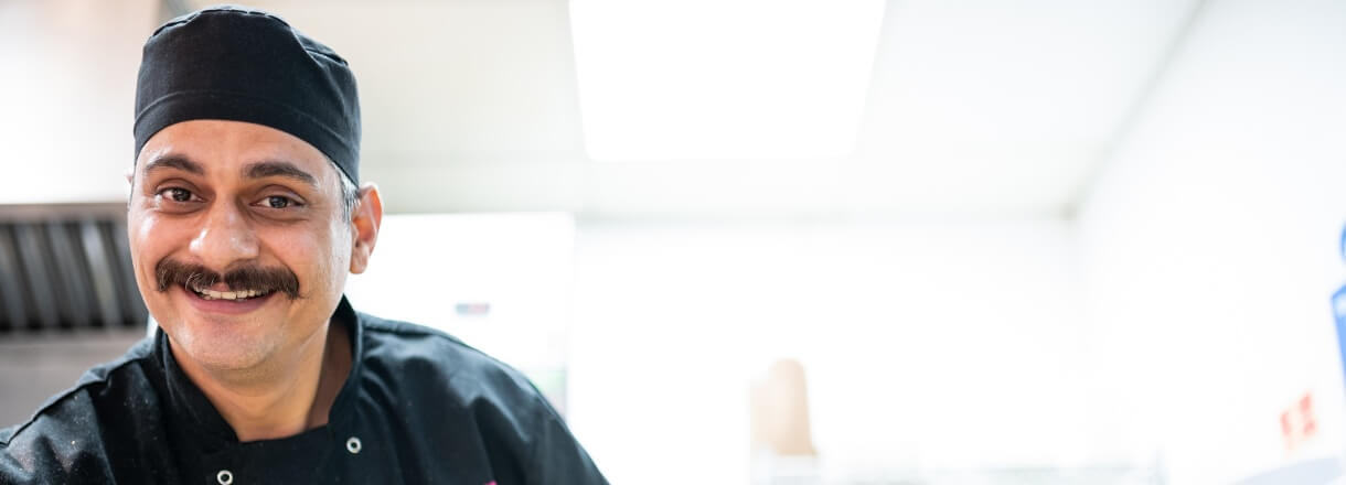Image of Head Chef in uniform smiling