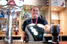 A smiling bar tender with a red lanyard serving a pint of pepsi.