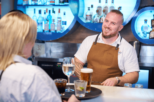man smiling behind bar