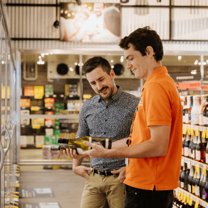 member of staff helping man with wine choice