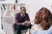 Smiling therapist talking to young couple