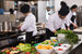 Professional team cooks and chefs preparing meals at busy professional kitchen