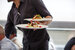Waiter carrying a plate with salad dish in a senior living community dining room