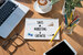 Aerial view of a work desk with sales, marketing and growth priorities written on a notepad