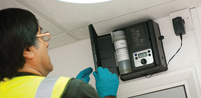 Ambius specialist installing a scenting device on a wall