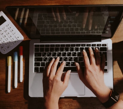 Pair of hand typing on a laptop