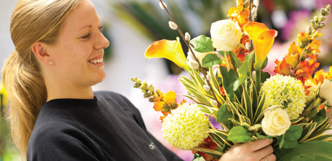 Ambius specialist with a bouquet of flowers