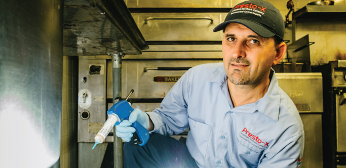 Presto-X technician with bait gun in a kitchen