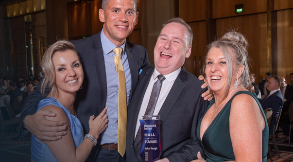 Colleagues hugging and smiling at an awards party