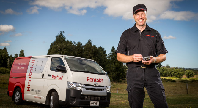 Pest technician posing in front of a van