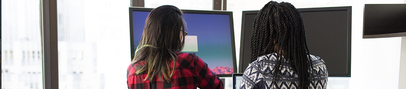 Two girls looking at computer screens