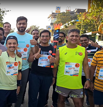 Employees holding a torch in running gear