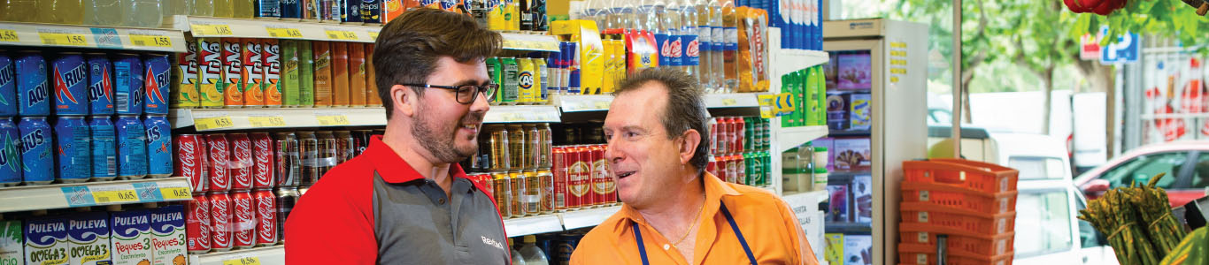 Pest technician speaking to supermarket worker in a supermarket