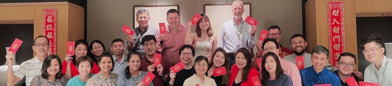 Group picture of Asia team holding red Rentokil cards