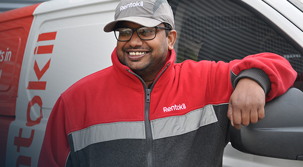 Pest technician leaning on his van