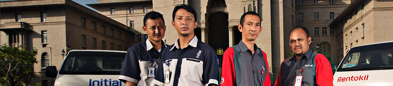 Initial and Rentokil technicians in front of their respective vans