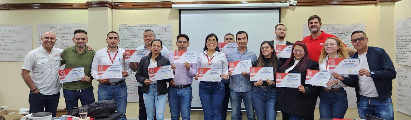 Alumnos mostrando su diploma de graduación en un aula