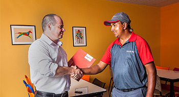 Técnico de Rentokil dando la mano a un cliente