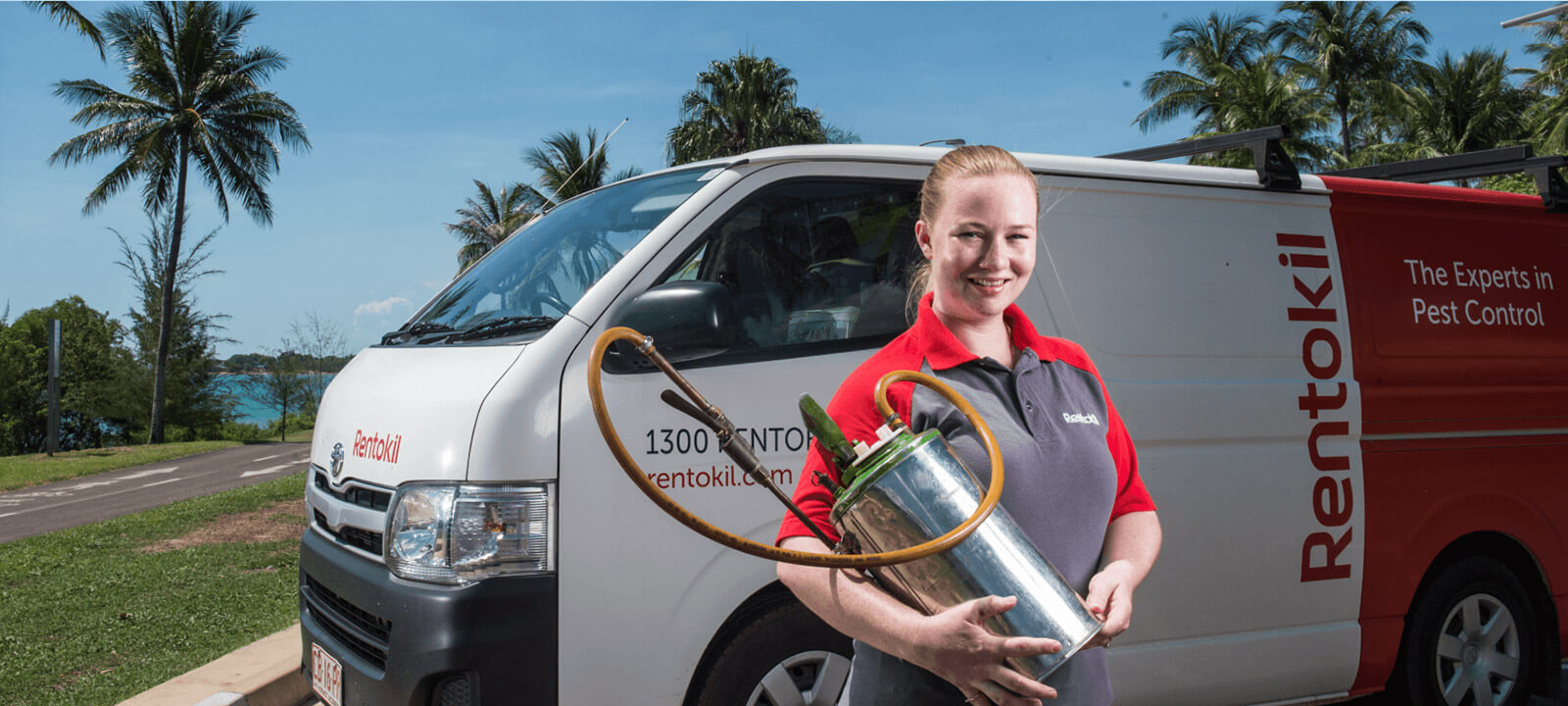 Rentokil colleague holding a sprayer in front of a service van