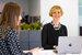 defined contribution person sitting at desk with laptop smiling 