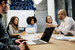 image of IT professionals sitting around a desk in a meeting 