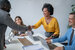 image of CRM professionals in a meeting sitting at desk 