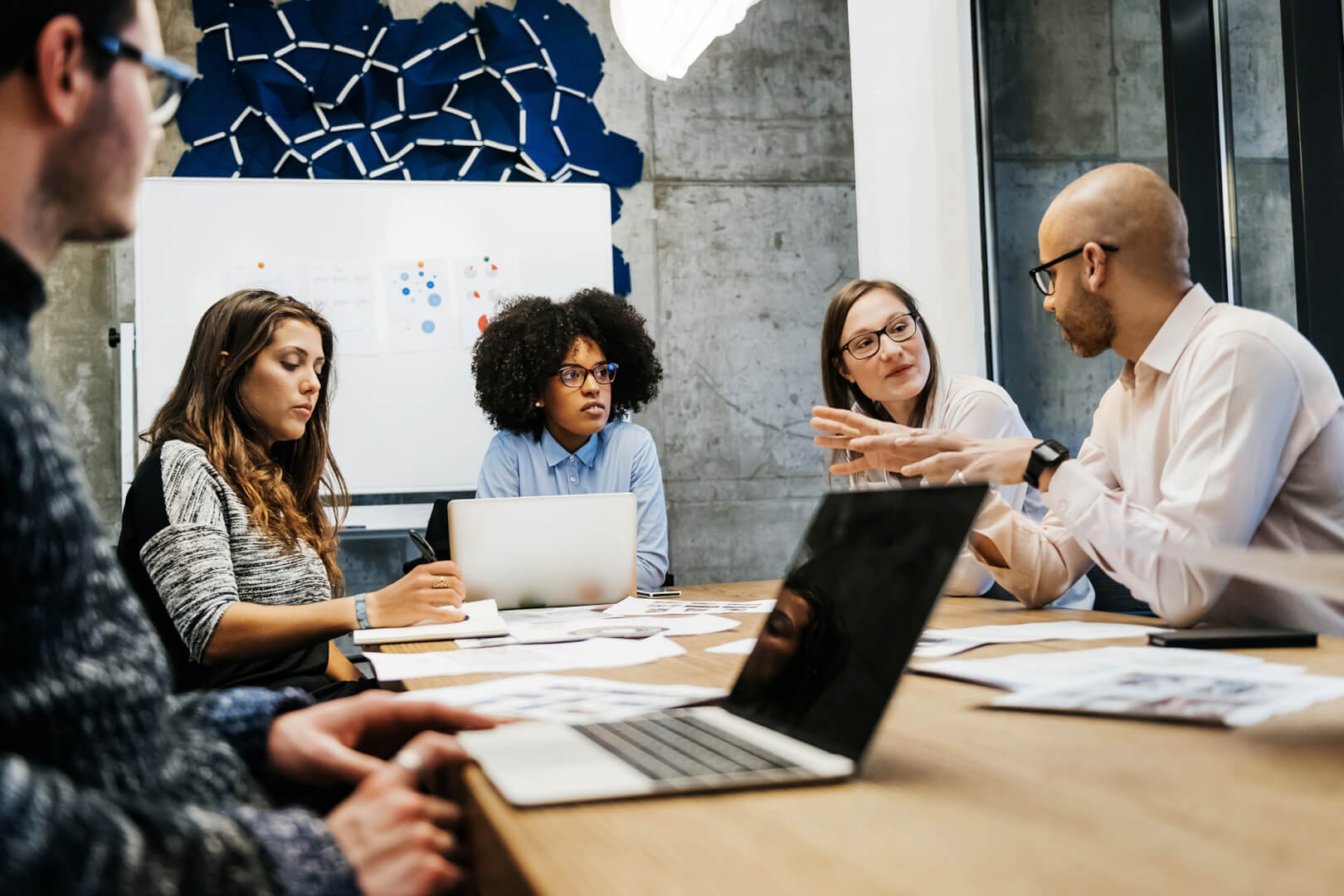 image of IT professionals sitting around a desk in a meeting 
