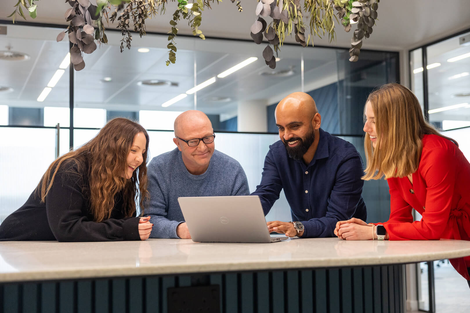 image of IT professionals surrounding a computer and smiling 