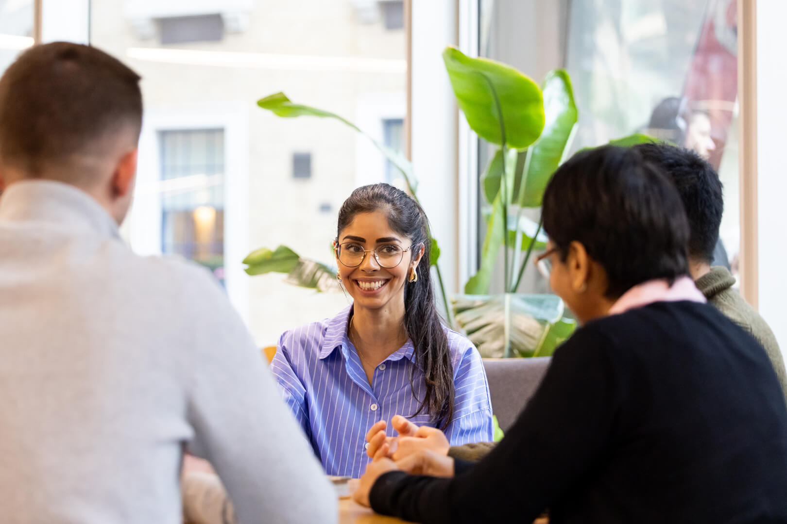 image of actuary smiling around a meeting table with other team members 