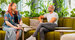 two employees smiling and sitting on the sofa together 