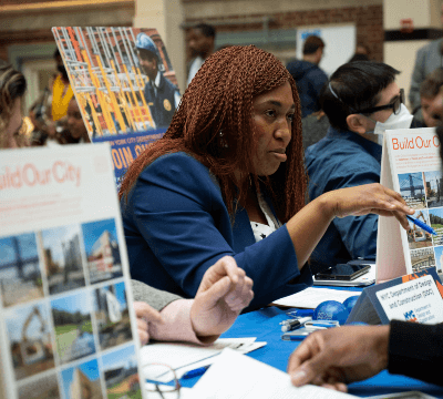  City employees at a hiring event helping attendees apply for jobs