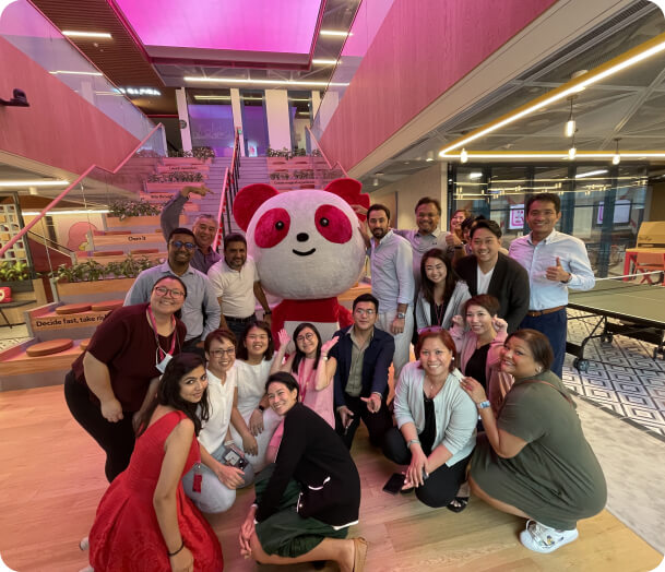 Excited Foodpanda staff gathered around a Pau Pau the panda mascot