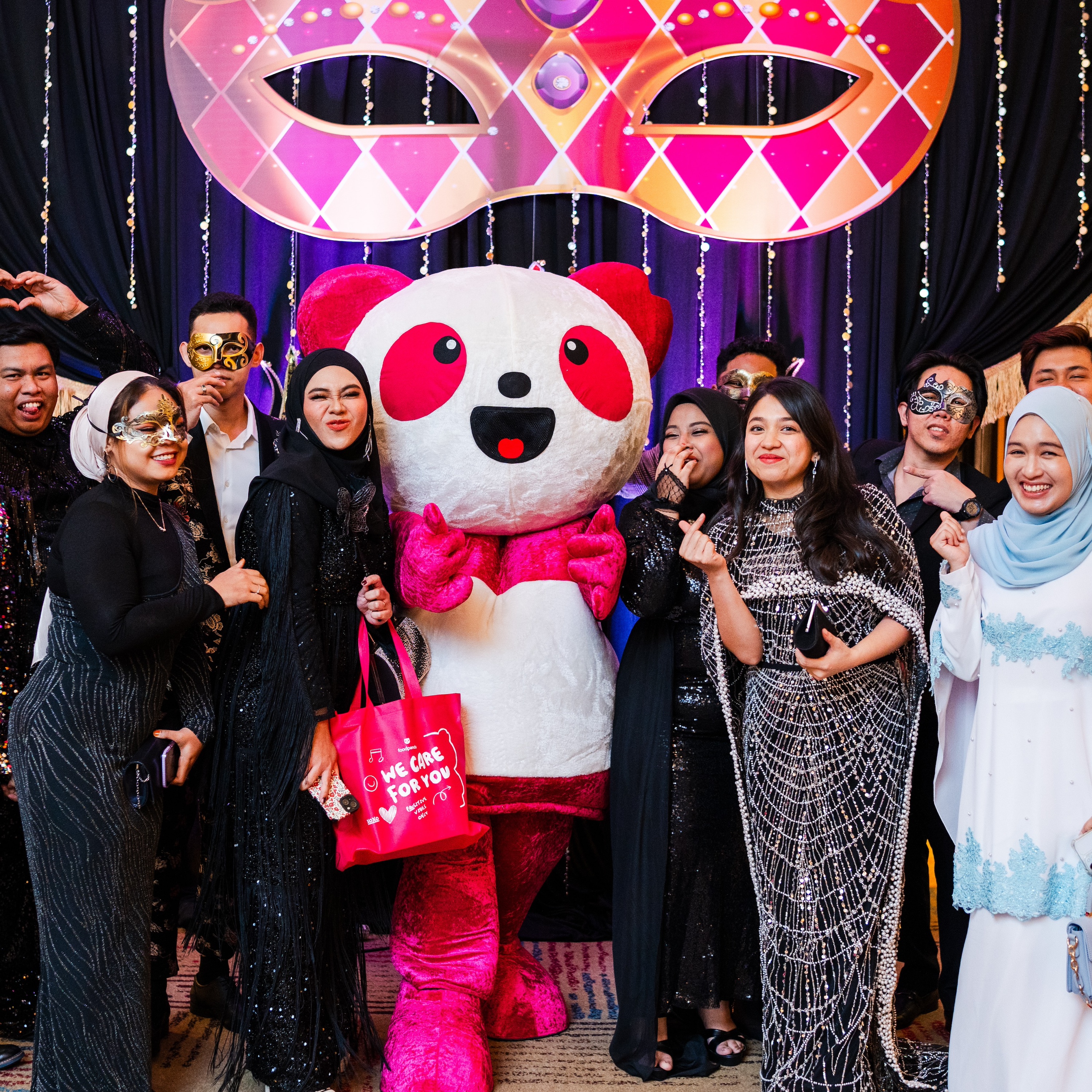 Excited foodpanda staff gathered around a Pau Pau the panda mascot