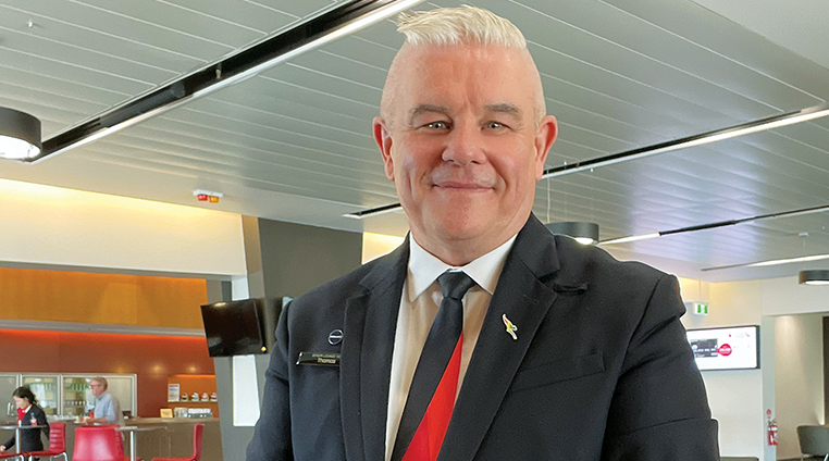 Qantas Lounge employee smiling at camera