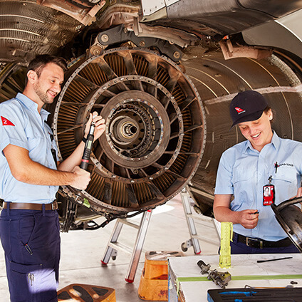 Two of our engineering apprentices working on the engine of a plane