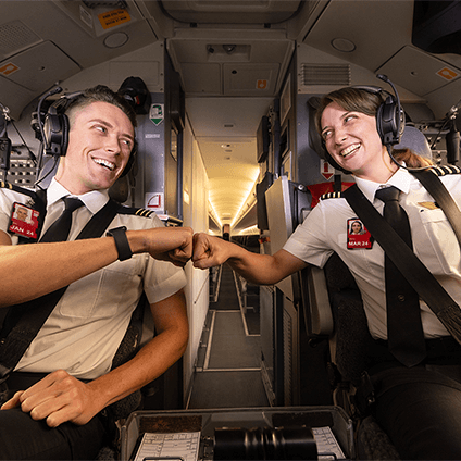 Two pilots bumping fists in the cockpit