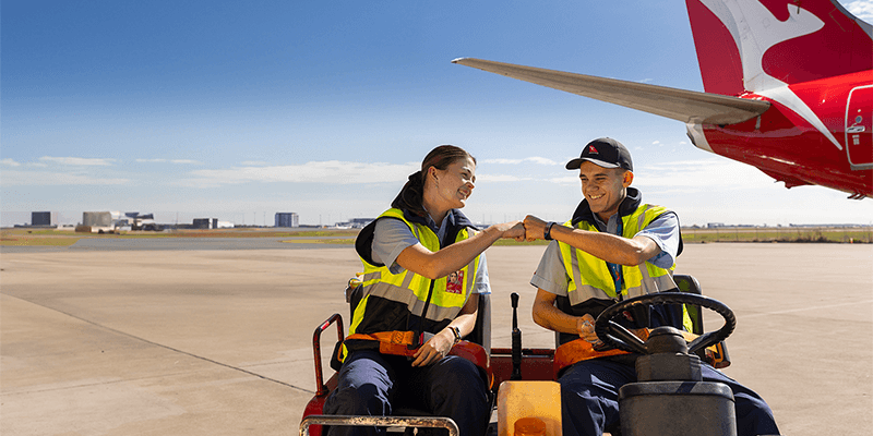 Engineering Apprentices on tarmac, bumping fists