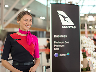 A customer service agent welcoming customers to the business class area