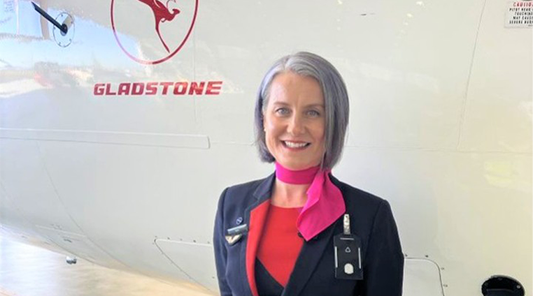 A Cabin crew member standing in front of a plane