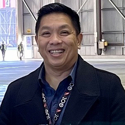 Employee at hangar smiling at camera