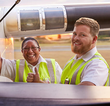 Two of our licensed aircraft maintenance engineers smiling at the camera