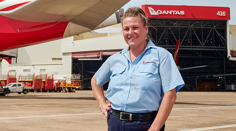 Qantas engineer on the tarmac, smiling at camera