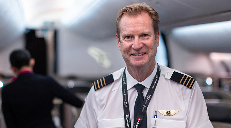 Qantas Pilot in cabin, smiling at camera