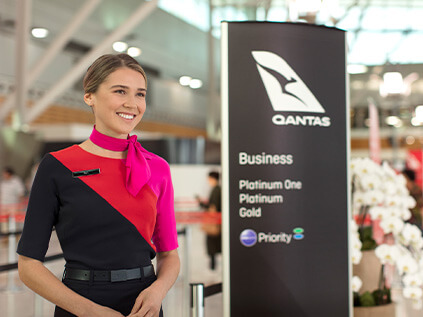 A customer service agent welcoming customers to the business class line