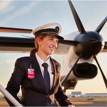 A QantasLink captain standing on the airstairs, smiling