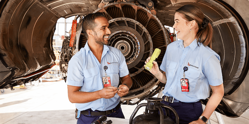 Qantas engineers working together on a plane engine