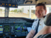 A pilot in the cockpit, smiling at camera