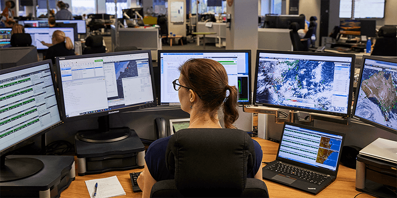 Qantas Meteorologist reviewing weather conditions on multiple screens