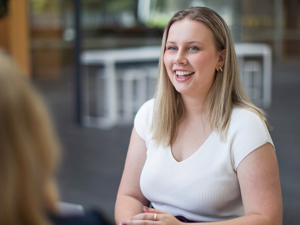 A First Nations trainee at Qantas, smiling at their colleagues